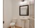 Cozy half-bath with pedestal sink, decorative mirror, and hardwood floors at 3006 Sea Aster Way, Buford, GA 30519