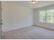 Bright bedroom features neutral carpet, a large window, and fresh paint at 3006 Sea Aster Way, Buford, GA 30519