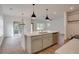 Bright, modern kitchen features a large island with sink and quartz countertops, perfect for cooking at 3006 Sea Aster Way, Buford, GA 30519