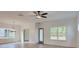 Open-concept living room with sleek ceiling fan, hardwood floors, and natural light from large windows at 3006 Sea Aster Way, Buford, GA 30519