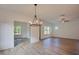 Spacious open living space with hardwood floors, modern lighting, and view to the outdoors through large windows at 3006 Sea Aster Way, Buford, GA 30519