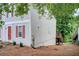 Charming townhouse featuring a quaint red door and red shutters, nestled in a serene, tree-lined neighborhood at 3999 Bayside Cir, Doraville, GA 30340