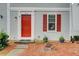 Inviting front door of townhome featuring red door, gray siding and tasteful landscaping at 3999 Bayside Cir, Doraville, GA 30340