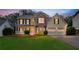 Charming two-story home with a well-manicured lawn, inviting front porch, and two-car garage at 4009 Riverstone Dr, Suwanee, GA 30024