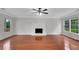 Open living room features hardwood floors, a fireplace, and large windows for natural light at 4009 Riverstone Dr, Suwanee, GA 30024