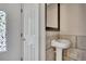 Cozy half-bathroom with pedestal sink and decorative mirror near the home's entrance at 6991 Flagstone Dr, Austell, GA 30168