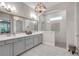Bathroom with double vanity, tiled shower, and decorative lighting fixtures at 219 Cordova St, Woodstock, GA 30189