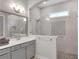 Bright bathroom featuring a tiled shower with a glass door and a double vanity at 219 Cordova St, Woodstock, GA 30189