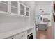 Butler pantry featuring white cabinets, countertops, and a wine refrigerator, open to the kitchen at 219 Cordova St, Woodstock, GA 30189