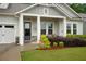The gray craftsman-style home features a charming covered porch at 219 Cordova St, Woodstock, GA 30189