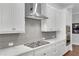 Stylish kitchen with white cabinets, stainless steel range hood, and gray tile backsplash at 219 Cordova St, Woodstock, GA 30189