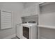 Well-equipped laundry room boasting modern washer and dryer units, along with ample storage for efficient chore management at 219 Cordova St, Woodstock, GA 30189