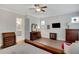 A bright main bedroom featuring wood floors, ceiling fan, and an ensuite bathroom at 219 Cordova St, Woodstock, GA 30189