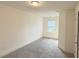 Well-lit carpeted bedroom with a large window, bright white trim, and a modern ceiling fan at 32 S Auburn Landing Pl, Auburn, GA 30011