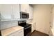 Modern townhouse kitchen with white cabinets, quartz countertops, and stainless appliances at 32 S Auburn Landing Pl, Auburn, GA 30011