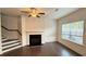 Open living room featuring a fireplace, ceiling fan and staircase to the second floor at 32 S Auburn Landing Pl, Auburn, GA 30011