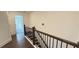 View of staircase with dark wood handrail and black iron balusters plus matching wood flooring at 32 S Auburn Landing Pl, Auburn, GA 30011