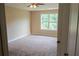 Cozy bedroom featuring plush carpet, neutral paint, and a large window with green views at 4527 Berline Dr, Lithonia, GA 30038