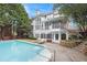 Expansive backyard featuring a swimming pool, patio with lounge chairs, and lush landscaping at 650 Garden Wilde Place, Roswell, GA 30075