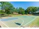 Community basketball court surrounded by lush trees offers recreational space for active residents at 650 Garden Wilde Place, Roswell, GA 30075