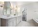 Elegant bathroom with dual marble vanities, sconce lighting, and a separate soaking tub at 650 Garden Wilde Place, Roswell, GA 30075