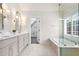 Bright bathroom with a double vanity, stylish lighting, and a glass-enclosed shower and soaking tub at 650 Garden Wilde Place, Roswell, GA 30075