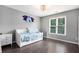 Comfortable bedroom with hardwood floors, a daybed, and a large window offering natural light at 650 Garden Wilde Place, Roswell, GA 30075