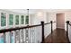 Bright hallway with hardwood floors, large windows overlooking the pool, and views of the living area below at 650 Garden Wilde Place, Roswell, GA 30075