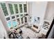 Sunlit living room with fireplace, built-in bookshelves, soaring ceilings, and expansive windows showcasing the pool at 650 Garden Wilde Place, Roswell, GA 30075