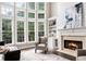 Light-filled living room with large windows, fireplace, and comfortable furnishings at 650 Garden Wilde Place, Roswell, GA 30075