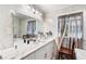 Elegant bathroom with marble walls, a modern sink and vanity, and natural light at 6628 Londonderry Dr, Morrow, GA 30260