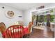 Inviting dining area featuring light from sunroom and dark laminate flooring at 6628 Londonderry Dr, Morrow, GA 30260
