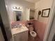 Bathroom features a sink with a mirror, toilet and pink tile at 301 Sisson Ne Ave, Atlanta, GA 30317