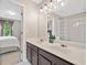 Bathroom featuring a double vanity, tub/shower with curtain, and views into bedroom at 4780 Agate Dr, Johns Creek, GA 30022