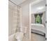 Bathroom boasts a tub/shower with curtain and a view into the bright bedroom at 4780 Agate Dr, Johns Creek, GA 30022