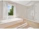 Spacious bathroom with tiled floors, large tub, bright windows, and glass shower at 4780 Agate Dr, Johns Creek, GA 30022