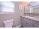 Clean bathroom with white cabinets, speckled countertop, and a framed mirror at 8321 Banks Mill Rd, Douglasville, GA 30135