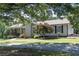 Charming single-story home featuring a stone chimney, covered porch, mature trees, and landscaped front yard at 8321 Banks Mill Rd, Douglasville, GA 30135
