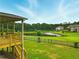 Expansive backyard featuring a tranquil pond, lush greenery and an outdoor space with wooden deck and stairs at 847 Rolling Hill, Kennesaw, GA 30152