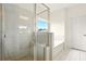 Shower with glass surround and bench, plus a tub and window to let in light at 847 Rolling Hill, Kennesaw, GA 30152
