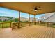 This outdoor covered deck features wooden floors, ceiling fan, and railing with view of the neighborhood at 847 Rolling Hill, Kennesaw, GA 30152