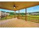 This covered deck features wooden floors, a ceiling fan, and overlooks a lake and neighborhood at 847 Rolling Hill, Kennesaw, GA 30152