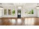 This bright living room features hardwood floors, large windows, and elegant chandeliers at 847 Rolling Hill, Kennesaw, GA 30152