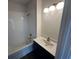 Well-lit bathroom with white tiled shower-tub, gold hardware and sink, and a dark vanity at 924 Hughley Circle # 82, Atlanta, GA 30316