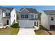 Charming two-story home featuring a one car garage and manicured front lawn at 12085 Conrad Circle, Hampton, GA 30228
