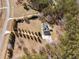 Aerial view of home, long driveway with evergreens, landscaping, and surrounding woods at 212 Lakeview Dr, Newborn, GA 30056