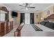 Spacious main bedroom with a ceiling fan, television, and luxurious, carved wooden furnishings at 212 Lakeview Dr, Newborn, GA 30056