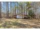 Detached outbuilding with garage door and covered parking in a wooded area at 212 Lakeview Dr, Newborn, GA 30056
