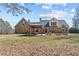 The rear exterior of this stone home features a large yard and an outdoor dining space at 212 Lakeview Dr, Newborn, GA 30056