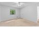 Bright bedroom features neutral carpet, ceiling fan, and a window with views of the trees outside at 2568 Redfield Dr, Norcross, GA 30071